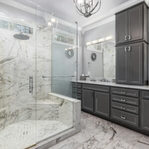Spacious bathroom featuring elegant marble shower and dark cabinetry.