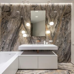 Elegant modern bathroom featuring marble walls, white fixtures, and stylish lighting.