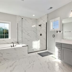 Spacious and elegant bathroom featuring marble tiles, glass shower, and modern vanity.